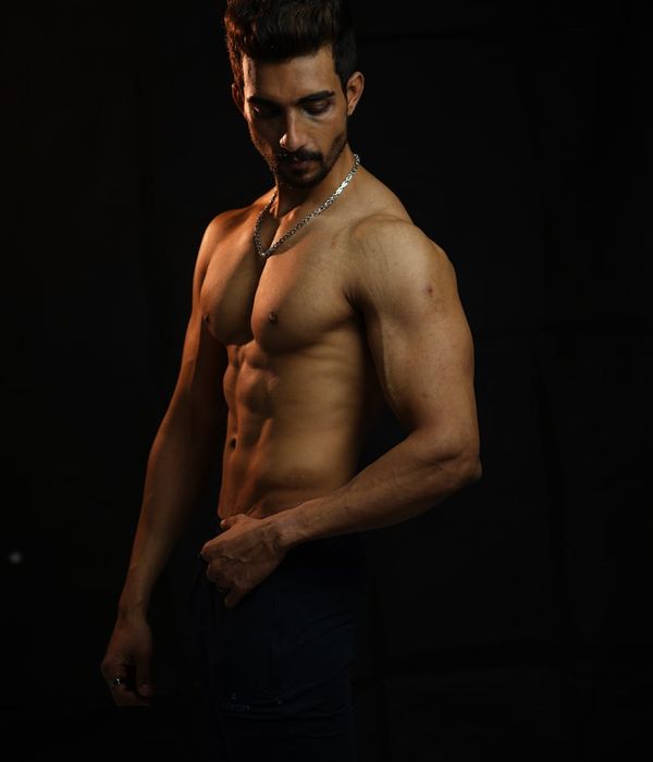 Man performing a controlled strength exercise in a dark room with amber lighting.